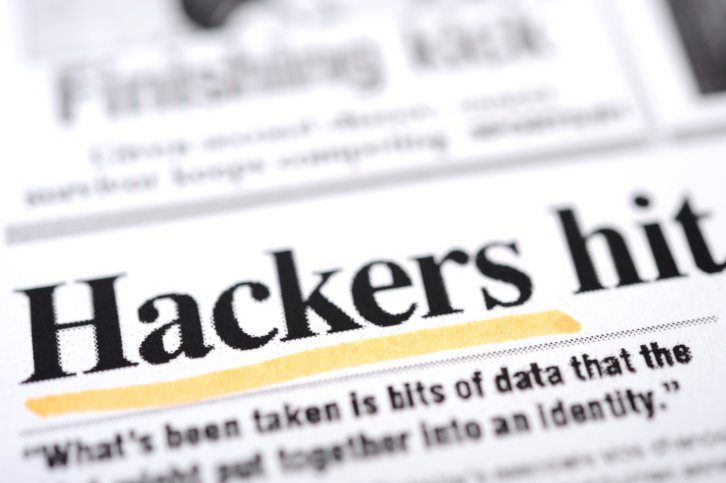 Snippet from a newspaper with the headline Hackers hit with Hackers underlined with yellow highlighter representing importance of IT security solutions